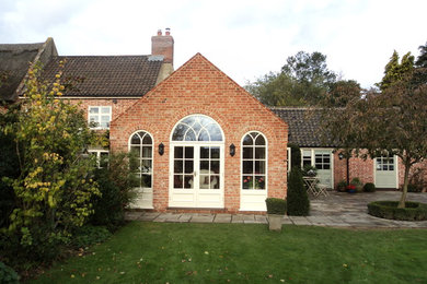 Photo of a country conservatory with terracotta flooring and a skylight.