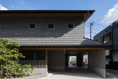 Exempel på ett modernt grått hus, med två våningar, sadeltak och tak i metall