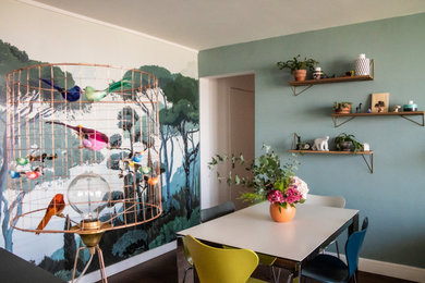 Cette image montre une salle à manger ouverte sur le salon design de taille moyenne avec un mur vert, un sol en bois brun, du papier peint, aucune cheminée et un sol marron.