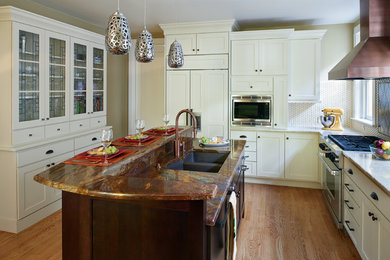Inspiration for a large transitional u-shaped medium tone wood floor eat-in kitchen remodel in Denver with an undermount sink, shaker cabinets, white cabinets, granite countertops, yellow backsplash, ceramic backsplash, stainless steel appliances and an island
