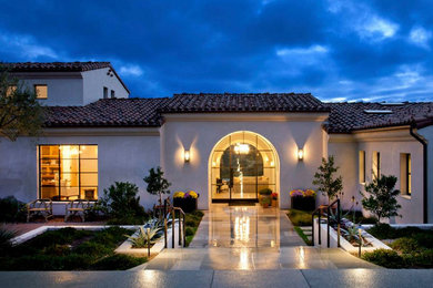 Inspiration for a large mediterranean white one-story stucco house exterior remodel in San Diego with a tile roof