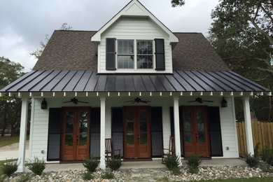 Large craftsman green two-story house exterior idea in Other with a clipped gable roof and a shingle roof