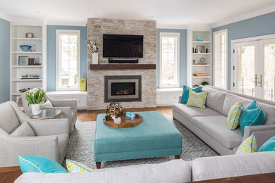 Photo of a mid-sized transitional enclosed family room in Toronto with blue walls, a standard fireplace, a wall-mounted tv, dark hardwood floors, a stone fireplace surround and brown floor.