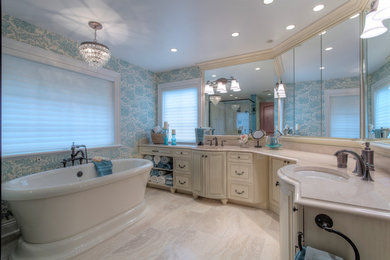 Photo of a traditional bathroom in Other with an undermount sink, raised-panel cabinets, white cabinets, a freestanding tub, blue walls and granite benchtops.