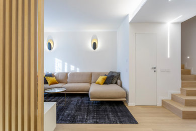 Источник вдохновения для домашнего уюта: открытая гостиная комната среднего размера в стиле модернизм с белыми стенами, светлым паркетным полом, телевизором на стене и ковром на полу