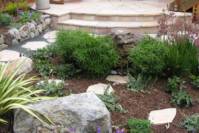 Photo of a mid-sized mediterranean backyard patio in San Francisco with a water feature, natural stone pavers and no cover.