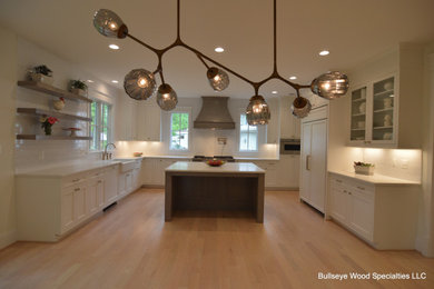 Example of a large arts and crafts u-shaped light wood floor and beige floor open concept kitchen design in DC Metro with a farmhouse sink, shaker cabinets, white cabinets, quartz countertops, white backsplash, porcelain backsplash, paneled appliances, an island and white countertops