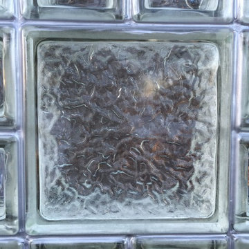 Metallic gray silicone jointing in this glass block window is matched to door ca