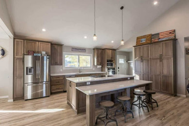 Eat-in kitchen - transitional vinyl floor, beige floor and vaulted ceiling eat-in kitchen idea in Minneapolis with an undermount sink, flat-panel cabinets, brown cabinets, quartz countertops, an island, white countertops and stainless steel appliances