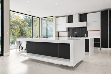 Inspiration for a large modern galley kitchen/diner in San Francisco with a submerged sink, glass-front cabinets, white cabinets, quartz worktops, black splashback, white appliances, multiple islands, white floors and white worktops.