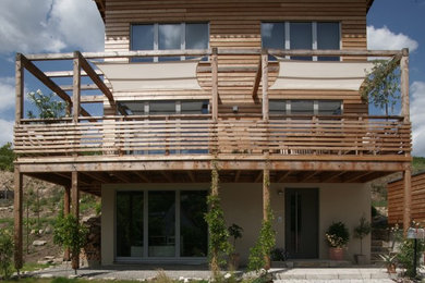 Mittelgroßes, Dreistöckiges Nordisches Haus mit beiger Fassadenfarbe, Pultdach, Ziegeldach und Verschalung in Sonstige