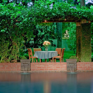 Inspiration för en mellanstor vintage anpassad baddamm på baksidan av huset, med en fontän och marksten i tegel