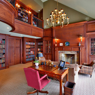 Inredning av ett klassiskt arbetsrum, med ett bibliotek, gröna väggar, heltäckningsmatta, en standard öppen spis och en spiselkrans i trä