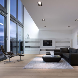 Diseño de salón para visitas abierto, contemporáneo, grande, sin chimenea, con paredes blancas, pared multimedia y suelo de madera en tonos medios
