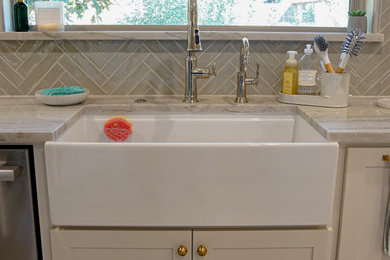 Inspiration for a large coastal u-shaped eat-in kitchen remodel in Dallas with no island, a farmhouse sink, glass-front cabinets, quartzite countertops, subway tile backsplash and stainless steel appliances