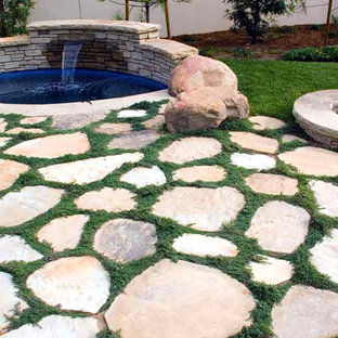 Foto på en liten vintage baddamm på baksidan av huset, med spabad och naturstensplattor