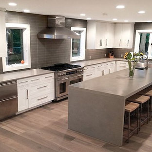 Large transitional kitchen pantry inspiration - Inspiration for a large transitional l-shaped medium tone wood floor kitchen pantry remodel in Orlando with a farmhouse sink, shaker cabinets, white cabinets, concrete countertops, gray backsplash, stainless steel appliances and an island