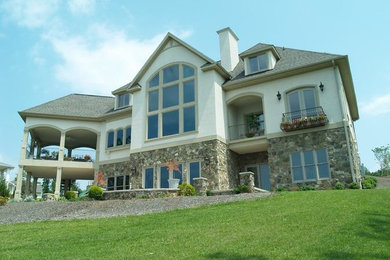 Beige two-story stone exterior home idea in Other