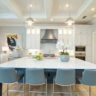 Cuisine avec un placard avec porte à panneau encastré et ...