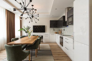 This is an example of a contemporary l-shaped eat-in kitchen in Saint Petersburg with an undermount sink, flat-panel cabinets, white cabinets, white splashback, glass sheet splashback, black appliances, medium hardwood floors, no island and brown floor.