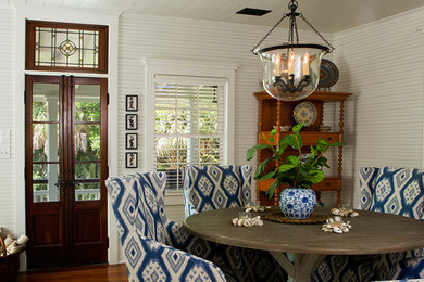 Small beach style dining room in Charleston with white walls and medium hardwood floors.