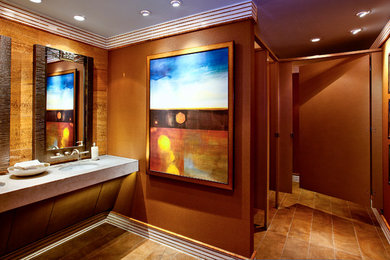 Imagen de cuarto de baño minimalista de tamaño medio con lavabo integrado, encimera de mármol, urinario, baldosas y/o azulejos marrones, imitación madera y paredes marrones