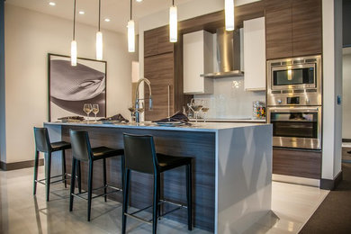 Design ideas for a mid-sized modern single-wall eat-in kitchen in Miami with flat-panel cabinets, with island, an undermount sink, brown cabinets, quartz benchtops, white splashback, glass tile splashback, stainless steel appliances, porcelain floors and white floor.