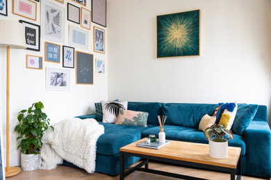 Imagen de salón abierto contemporáneo de tamaño medio sin chimenea con paredes blancas, suelo de madera clara, televisor independiente, suelo beige y papel pintado