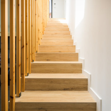 Escaleras de madera distribuyen los diferentes espacios de la casa en Sant Fost