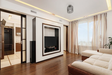 Стильный дизайн: изолированная гостиная комната среднего размера в современном стиле с бежевыми стенами, темным паркетным полом, отдельно стоящим телевизором и коричневым полом без камина - последний тренд