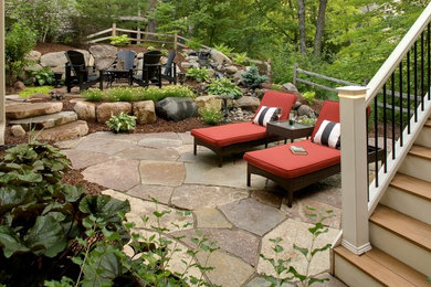 Photo of a mid-sized traditional backyard patio in Minneapolis with a fire feature, natural stone pavers and no cover.