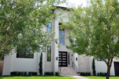 Inspiration for a large contemporary white two-story stucco exterior home remodel in Houston