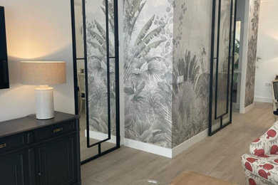 Foto de salón abierto tradicional renovado grande con paredes blancas, suelo de madera clara, televisor colgado en la pared y papel pintado