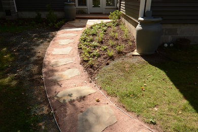 Inspiration for a traditional backyard partial sun garden in Other with natural stone pavers.