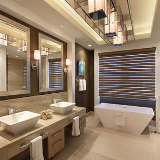 Large trendy master beige tile and ceramic tile limestone floor bathroom photo in Miami with a vessel sink, flat-panel cabinets, light wood cabinets, marble countertops and beige walls