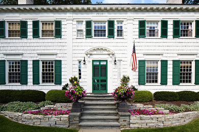 Large elegant white two-story wood house exterior photo in Other