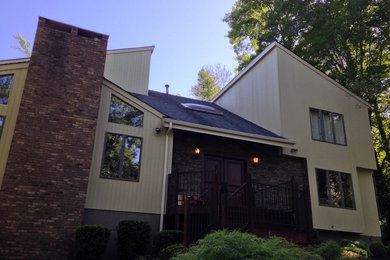 Inspiration for a large contemporary beige two-story wood exterior home remodel in New York with a shed roof