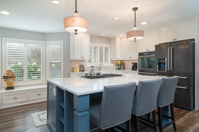 Inspiration for a mid-sized country l-shaped medium tone wood floor eat-in kitchen remodel in Portland with white cabinets and an island