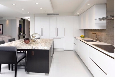 Inspiration for a large modern l-shaped porcelain tile kitchen remodel in Miami with a single-bowl sink, flat-panel cabinets, white cabinets, quartzite countertops, gray backsplash, mosaic tile backsplash and paneled appliances