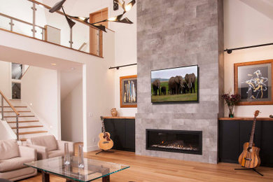 Inspiration for a large eclectic formal and open concept light wood floor, brown floor and vaulted ceiling living room remodel in Seattle with white walls, a ribbon fireplace, a tile fireplace and a wall-mounted tv