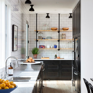 Nordische Wohnküche ohne Insel mit Unterbauwaschbecken, Schrankfronten im Shaker-Stil, schwarzen Schränken, Marmor-Arbeitsplatte, Küchenrückwand in Weiß, Rückwand aus Metrofliesen, Küchengeräten aus Edelstahl und hellem Holzboden in Austin