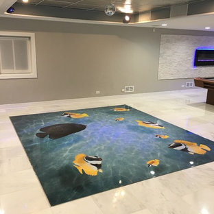 This is an example of a large modern walk-out basement in Chicago with grey walls, marble flooring, a stone fireplace surround and a ribbon fireplace.