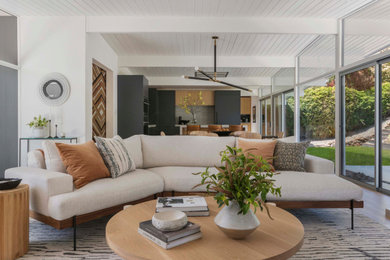 Example of a trendy open concept light wood floor and exposed beam living room design in San Francisco with white walls