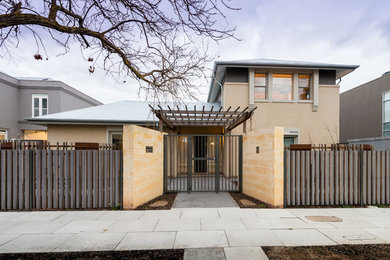 Photo of a contemporary two-storey brick beige house exterior in Adelaide with a gable roof and a metal roof.