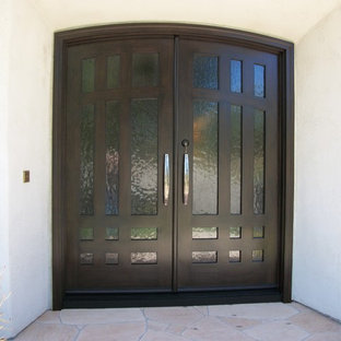 Пример оригинального дизайна интерьера: входная дверь среднего размера в средиземноморском стиле с белыми стенами, полом из травертина, двустворчатой входной дверью, входной дверью из темного дерева и бежевым полом