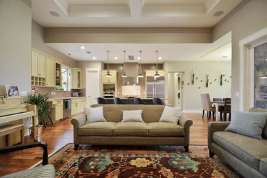 Example of a mid-sized transitional medium tone wood floor open concept kitchen design in Austin with an undermount sink, shaker cabinets, yellow cabinets, quartz countertops, multicolored backsplash, mosaic tile backsplash, stainless steel appliances and an island