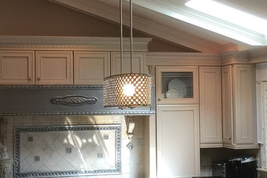 Example of a mid-sized minimalist l-shaped enclosed kitchen design in Other with an undermount sink, recessed-panel cabinets, white cabinets, beige backsplash, ceramic backsplash, stainless steel appliances and an island