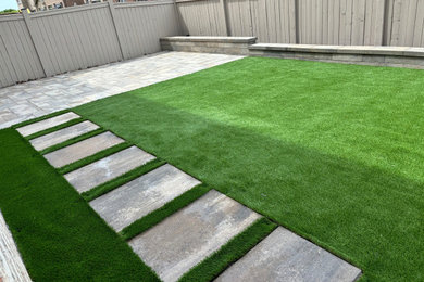 Inspiration for a mid-sized modern full sun backyard concrete paver landscaping in Toronto.