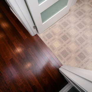 Inspiration för mellanstora klassiska hallar, med vita väggar, rött golv och mellanmörkt trägolv