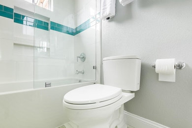 Mid-sized transitional kids bathroom in Los Angeles with recessed-panel cabinets, white cabinets, a shower/bathtub combo, a two-piece toilet, grey walls, porcelain floors, an undermount sink, an alcove tub, white tile, porcelain tile, engineered quartz benchtops, multi-coloured floor and an open shower.